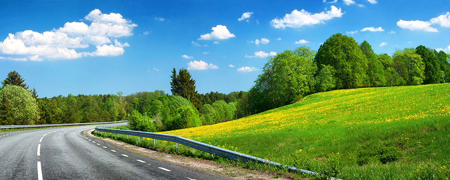 Stock Photo Of A Highway With Green Fields and A Blue Sky - Representing Rollac's Clear Vision