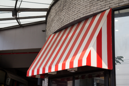 Drop arm awning in red and white stripe design