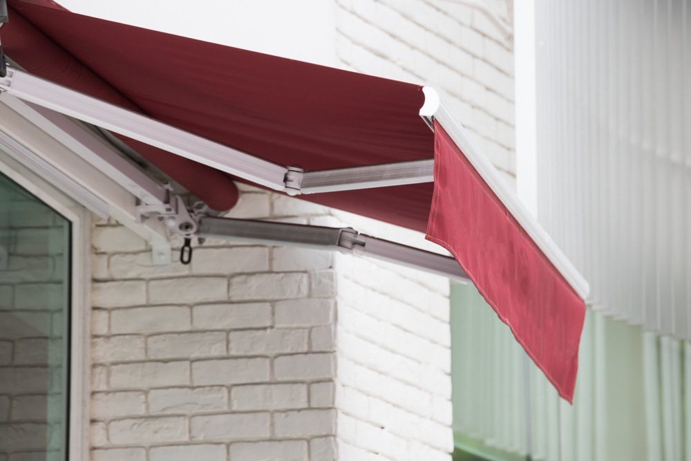Window with red fabric retractable awning
