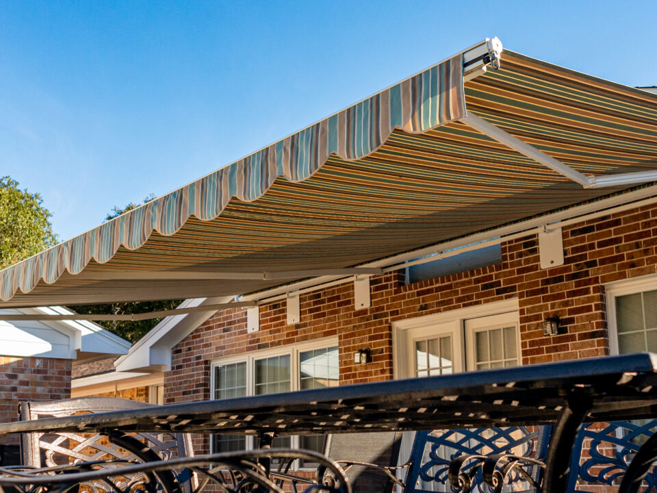 Large Retractable Awning with Green, Orange, and Brown Stripes