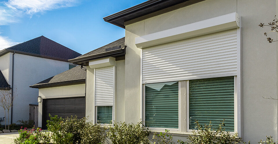 Exterior View of a House with White Hurricane Shutters Installed at the Windows