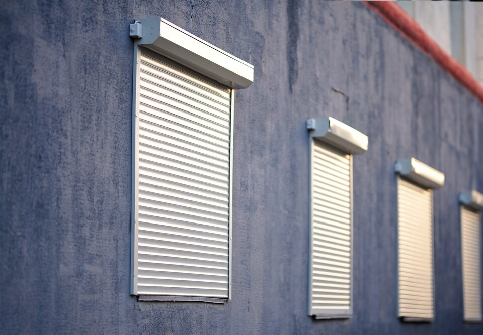 House Facade with Windows with Closed Security Rolling Shutters