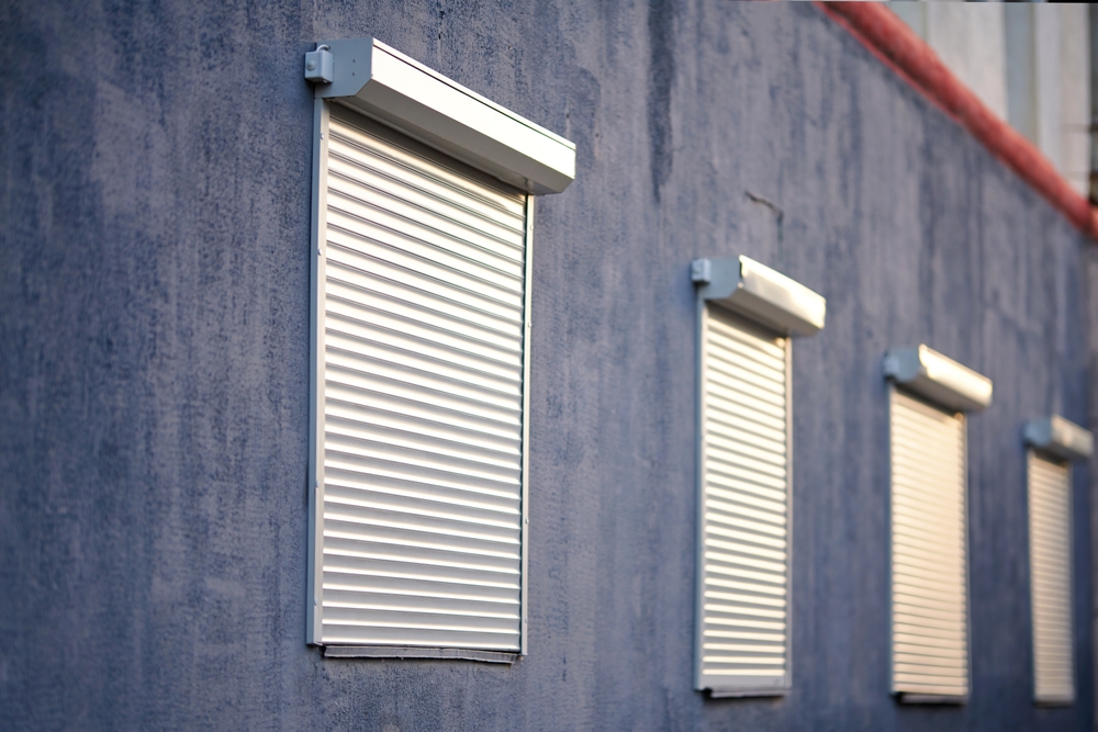 House Facade with Windows with Closed Security Rolling Shutters